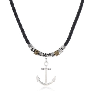 Close-up of nautical anchor pendant with vintage beads and black braided cord necklace