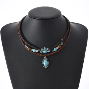 Bohemian multi-layer necklace with turquoise pendant and woven cords on mannequin
