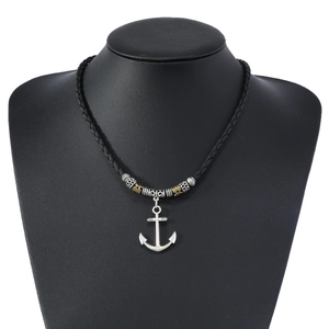 Close-up of nautical anchor pendant on braided leather cord with engraved metal beads