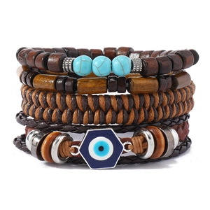Detail of layered turquoise and wood bead bracelet with Evil Eye charm and woven leather