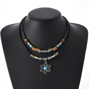 Detail of bohemian layered necklace featuring vintage flower pendant and turquoise beads
