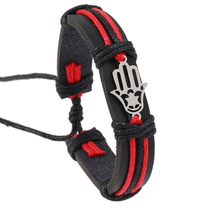 Detail of woven black leather and red rope bracelet with silver Hamsa hand charm