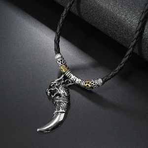 Detailed view of punk style wolf head pendant with silver fang on black braided cord necklace