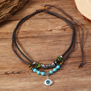 Bohemian multilayer turquoise beaded necklace with evil eye pendant on wooden background
