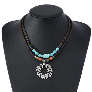Détail du collier bohème à plusieurs rangs avec perles turquoise et pendentif feuille