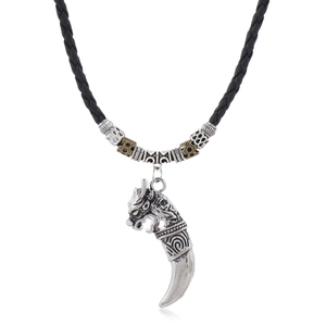 Detail of vintage dragon tooth pendant necklace with black braided cord and beads