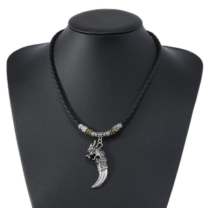 Detail of vintage wolf head pendant on black braided rope necklace for men