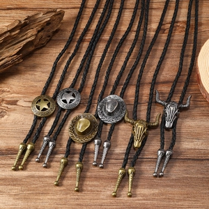 Vintage western bolo ties with bull skull and star pendants on a rustic wood background