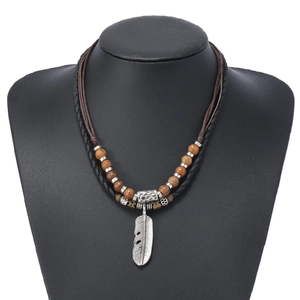 Détail du collier multicouche rétro avec perles en bois et pendentif plume en alliage gravé