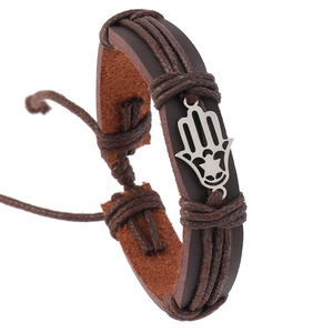 Detailed macro view of dark brown multilayer leather bracelet with silver Hamsa hand charm