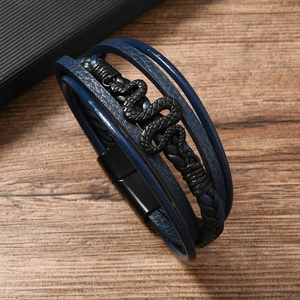 Détail d'un bracelet multicouche en cuir avec un charm serpent en métal noir texturé