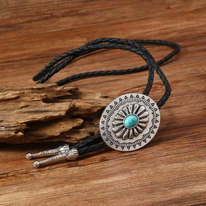 Détail d'une cravate bolo avec incrustation turquoise et fermoir argenté effet soleil