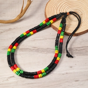 Detail of bohemian layered wood bead necklace with red yellow green flat beads on wood