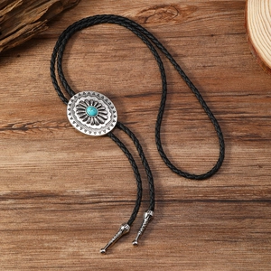 Cravate bolo rétro avec pendentif turquoise et embouts gravés sur fond en bois rustique