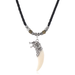 Macro view of vintage tribal wolf head pendant with carved details and faux ivory charm