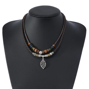 Détail d'un collier tressé double couche avec perles colorées et pendentif feuille