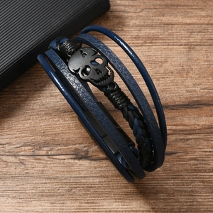 Detail of punk multilayer braided leather bracelet with black matte skull metal clasp