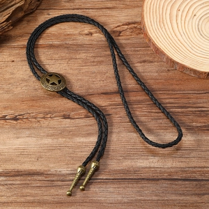 Close-up of vintage bronze bolo tie with hollow star motif and black braided leather cord