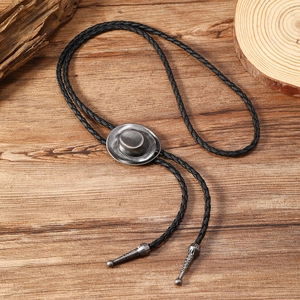 Detail of western bolo tie featuring silver cowboy hat pendant and black braided rope