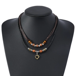 Détail d'un collier double couche vintage avec perles en bois et pendentif coeur