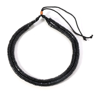 Detail of double-layer black wooden bead necklace with vintage orange accent bead