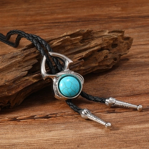Cravate bolo western vintage avec pendentif turquoise sur fond de bois rustique