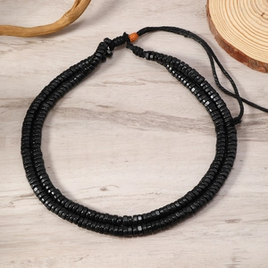 Detail of double-layer black wooden bead necklace with ethnic pattern accent bead