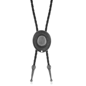 Detail of vintage silver cowboy hat bolo tie with black braided rope and engraved metal tips
