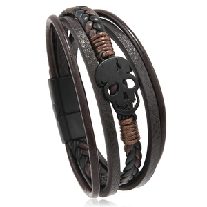 Detail of multi-layer braided leather bracelet with black skull and magnetic clasp