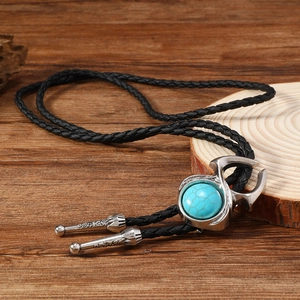 Détail de la cravate bolo vintage avec incrustation turquoise et cuir tressé