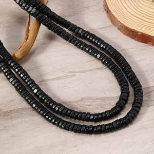 Close-up of black wooden abacus beads on a natural wood textured surface decoration
