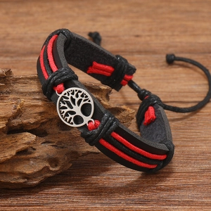 Close-up of leather braided bracelet with red wax cords and silver tree of life charm