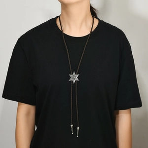 Détail d'une cravate bolo hexagramme en argent vintage avec cordon en cuir
