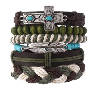 Détail de bracelets multicouches en cuir avec pendentifs de croix et plume vintage