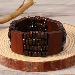 Detail of bohemian brown wood bead bracelet texture on natural rustic wooden stand