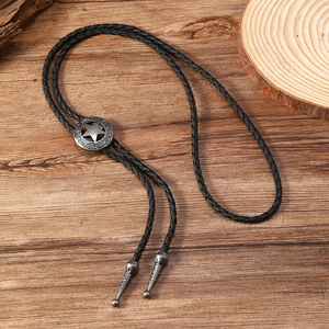 Detail of vintage bolo tie with star embossed slider on a rustic wood background