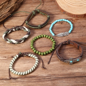 Détail d'un ensemble de 6 bracelets bohèmes en cuir et perles avec breloques plume et croix