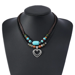 Détail d'un collier bohème à double couche avec perles turquoise et pendentif cœur