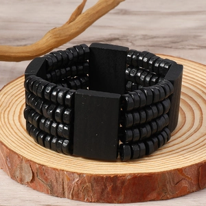 Men's bohemian black multi-layer wooden bead bracelet on a natural rustic wood slice