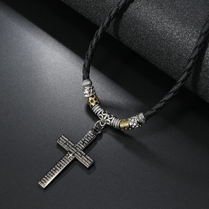 Macro view of black cross necklace with Spanish bible verses and metal beads