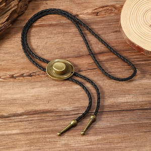 Detailed view of vintage cowboy hat bolo tie with antique bronze pendant and woven cord
