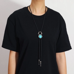 Détail de la cravate Bolo vintage avec pendentif turquoise sur cordon tressé noir