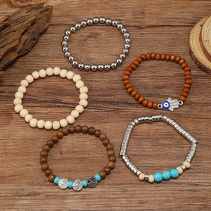 Detail of five-piece multilayer beaded bracelet set with turquoise and tree of life charms