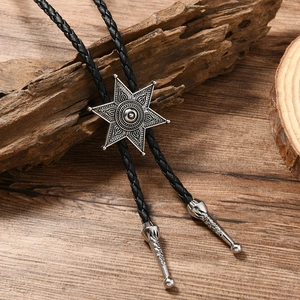 Détail d'un bolo tie hexagramme vintage avec cordon en cuir tressé sur bois rustique