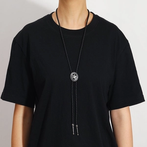 Close-up of vintage silver star bolo tie with black braided leather and metal tips