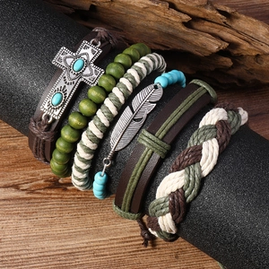 Détail macro de bracelets multicouches bohèmes avec croix en alliage et breloques plumes