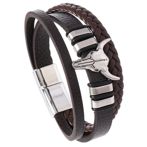 Detail eines mehrlagigen Lederarmbands mit silbernem Stierkopf und Magnetverschluss