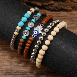 Detail of bohemian turquoise beaded bracelet set with Hamsa hand and tree of life charms
