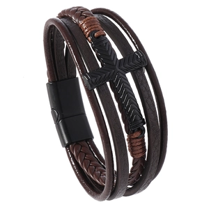 Macro shot of multi-layer braided leather bracelet with cross and magnetic buckle