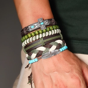 Vue détaillée du bracelet multicouche bohème avec croix en métal vintage et breloques plumes